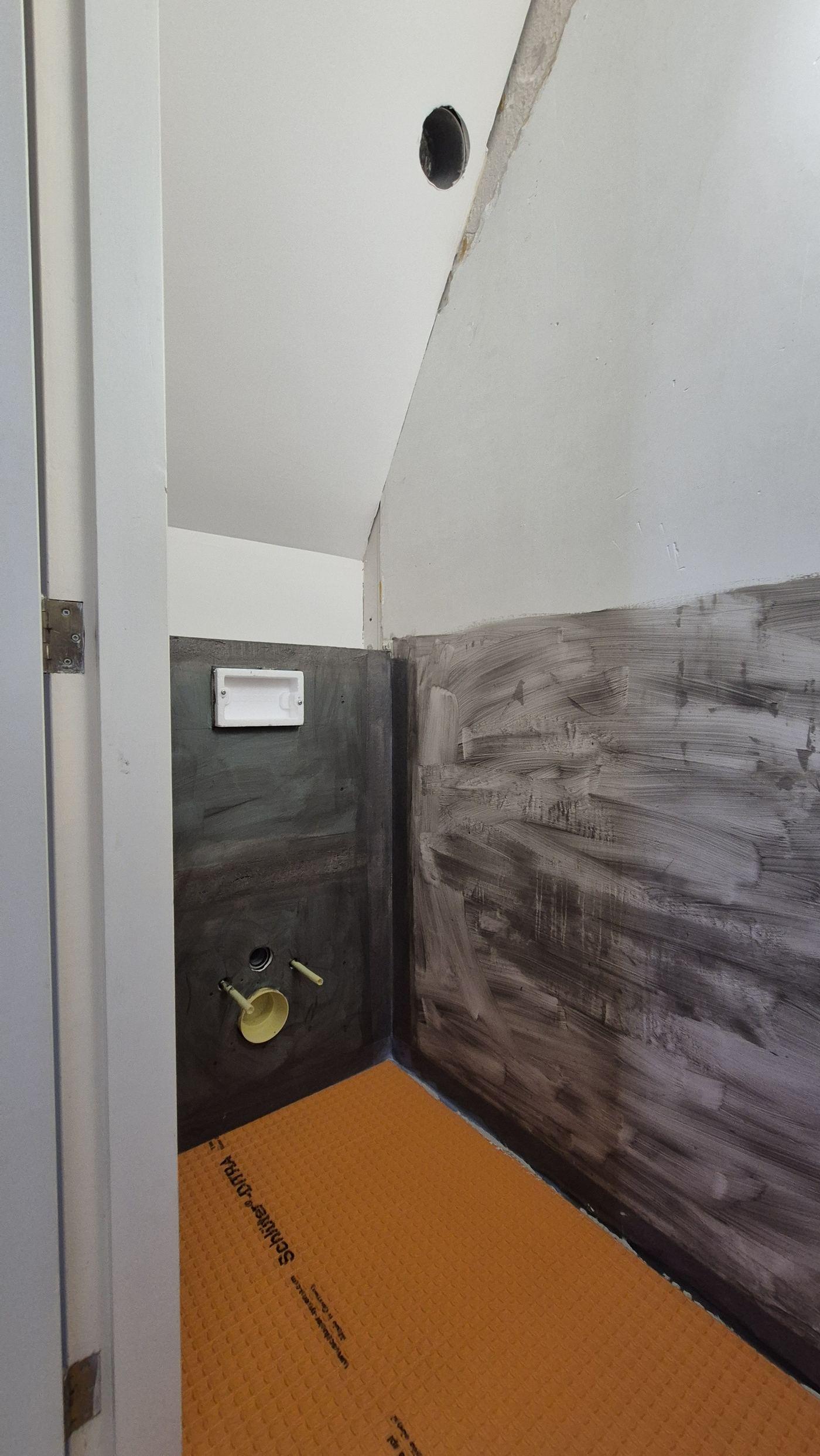 Bathroom in progress: waterproofing membrane and a wall-hung toilet frame before tiling, Amstelveen 2026