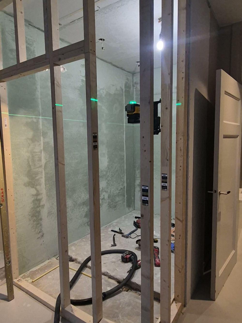 Houten regelwerk voor een nieuwe wand, uitgezet met een groene laser, in Oud-Zuid (in uitvoering).